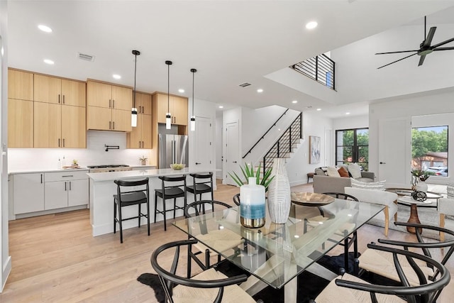 2303 Westworth Cir, Austin, TX 78704 - dining room featuring stairway, light wood-type flooring, recessed lighting, ceiling fan, and a high ceiling