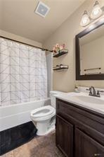 205 W Little Dipper Dr, Killeen, TX 76542 - full bath with vanity, toilet, shower / bathtub combination with curtain, and vaulted ceiling