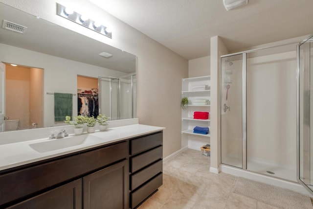 11404 Day Camp Ln, Austin, TX 78754 - bathroom featuring a walk in closet, vanity, a stall shower, and toilet