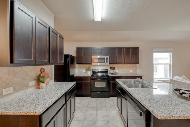 11404 Day Camp Ln, Austin, TX 78754 - kitchen featuring black appliances, a sink, backsplash, a kitchen island with sink, and dark brown cabinets