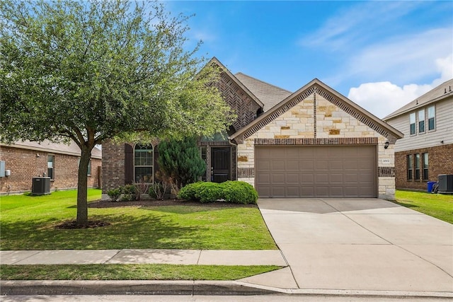 2002 S Ash Cv, Hutto, TX 78634 - french country home with stone siding, an attached garage, a front lawn, and central AC unit