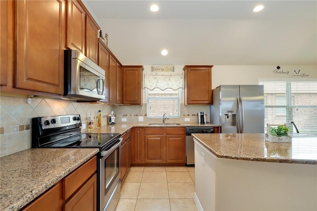 2002 S Ash Cv, Hutto, TX 78634 - kitchen with stainless steel appliances, a sink, light stone countertops, decorative backsplash, and recessed lighting
