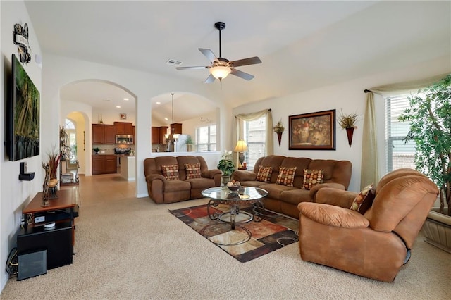 2002 S Ash Cv, Hutto, TX 78634 - carpeted living room featuring ceiling fan, arched walkways, and healthy amount of natural light
