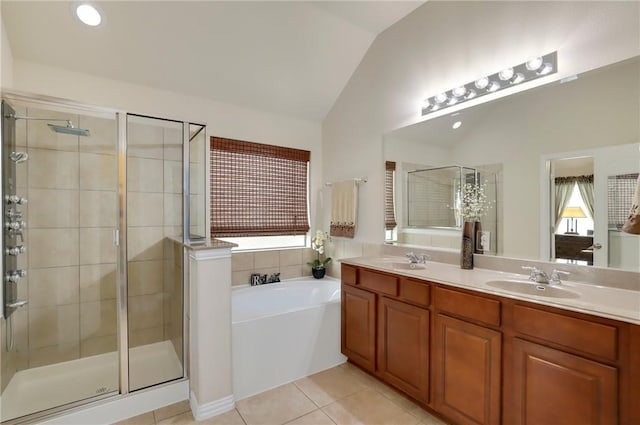 2002 S Ash Cv, Hutto, TX 78634 - full bath with lofted ceiling, a stall shower, a bath, double vanity, and tile patterned floors