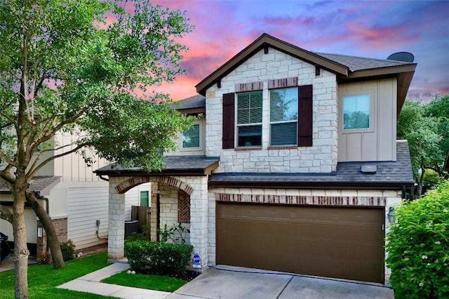 7709 Menchaca Rd Unit 16, Austin, TX 78745 - view of front of house featuring a shingled roof, board and batten siding, a garage, and stone siding