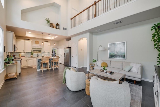 7709 Menchaca Rd Unit 16, Austin, TX 78745 - living room featuring arched walkways, baseboards, and a high ceiling