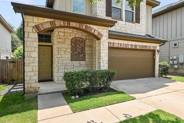 7709 Menchaca Rd Unit 16, Austin, TX 78745 - view of exterior entry with stone siding, a garage, board and batten siding, and concrete driveway