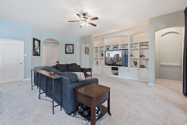 3217 Falconers Way, Pflugerville, TX 78660 - living area with arched walkways, light colored carpet, ceiling fan, baseboards, and built in shelves