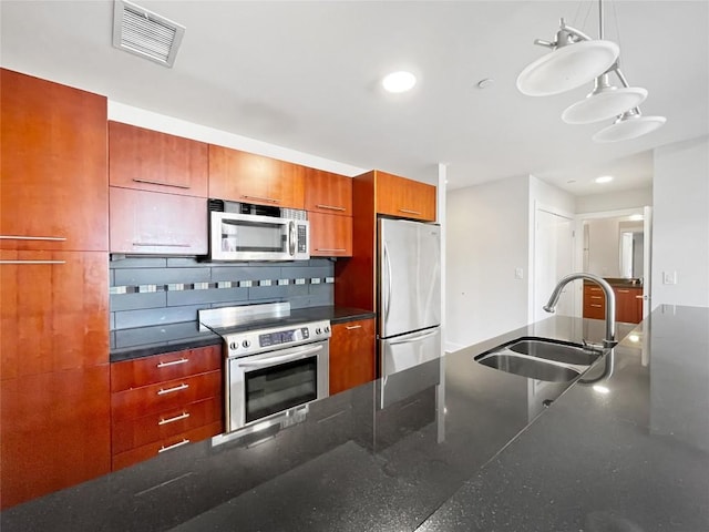 603 Davis St Unit 1108, Austin, TX 78701 - kitchen featuring appliances with stainless steel finishes, a sink, brown cabinets, decorative light fixtures, and recessed lighting