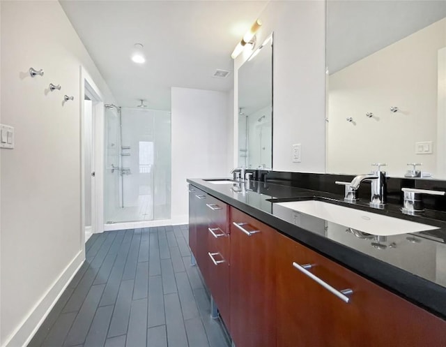 603 Davis St Unit 1108, Austin, TX 78701 - full bath featuring a shower stall, double vanity, baseboards, and wood tiled floors