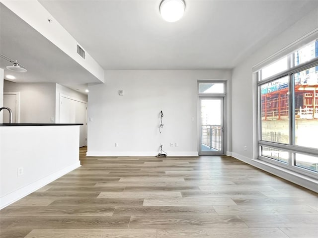 603 Davis St Unit 1108, Austin, TX 78701 - unfurnished living room featuring light wood-style floors and baseboards