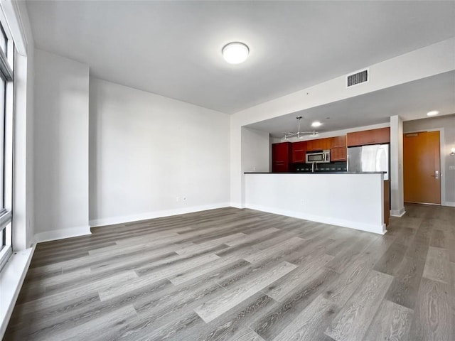 603 Davis St Unit 1108, Austin, TX 78701 - unfurnished living room featuring light wood-type flooring and baseboards