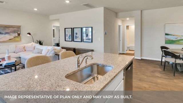 13700 Bothwell Pl, Manor, TX 78653 - kitchen with a sink, wood finished floors, stainless steel dishwasher, light stone counters, and recessed lighting