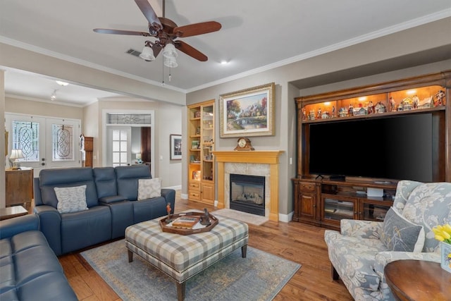 115 Durango Trl, Georgetown, TX 78633 - living room with wood finished floors, ceiling fan, a tiled fireplace, baseboards, and ornamental molding