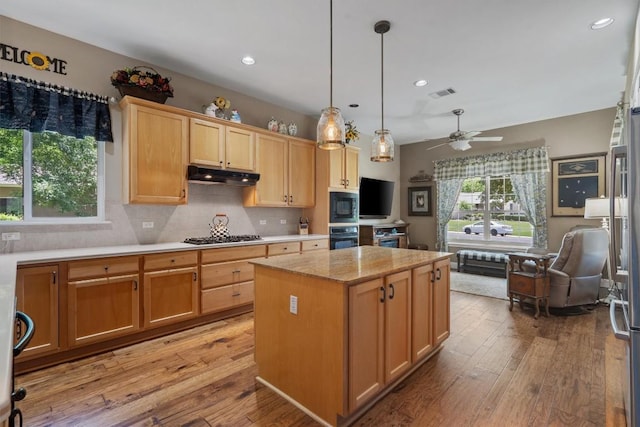 115 Durango Trl, Georgetown, TX 78633 - kitchen featuring oven, under cabinet range hood, built in microwave, a kitchen island, and stainless steel gas cooktop
