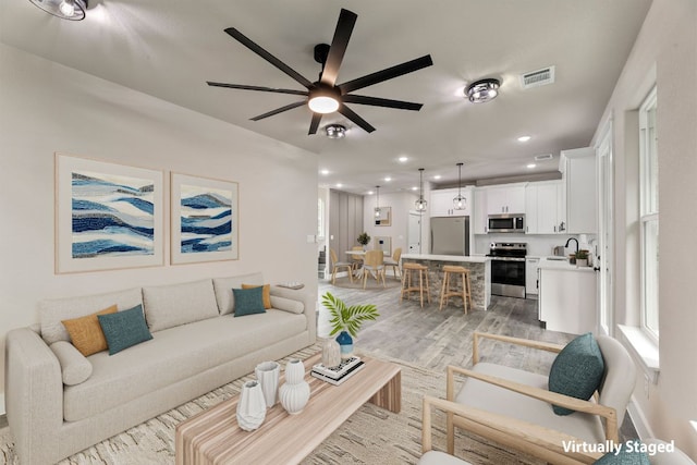 182 Kaanapali Ln, Bastrop, TX 78602 - living area with light wood finished floors, a ceiling fan, and recessed lighting