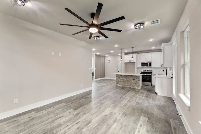 182 Kaanapali Ln, Bastrop, TX 78602 - unfurnished living room featuring a ceiling fan, light wood-style floors, and recessed lighting