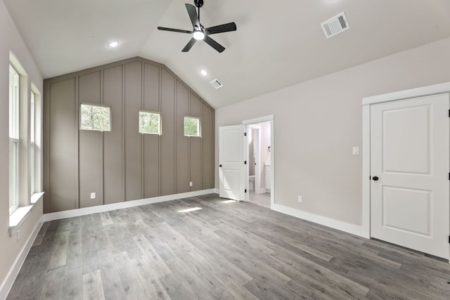 182 Kaanapali Ln, Bastrop, TX 78602 - unfurnished bedroom with lofted ceiling, wood finished floors, multiple windows, ensuite bathroom, and recessed lighting