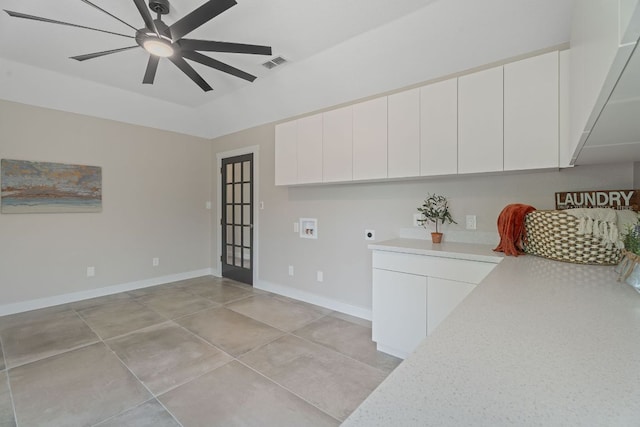 100 Toltec Cv, Kyle, TX 78640 - kitchen with light countertops, ceiling fan, white cabinets, baseboards, and light tile patterned floors