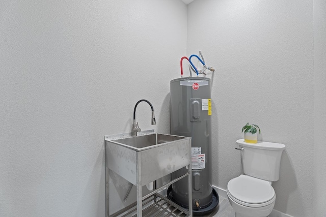 100 Toltec Cv, Kyle, TX 78640 - bathroom with water heater, a sink, toilet, and baseboards