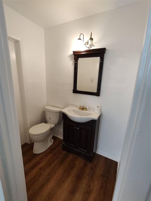 405 Oertli Ln, Austin, TX 78753 - half bathroom featuring vanity, wood finished floors, toilet, and baseboards
