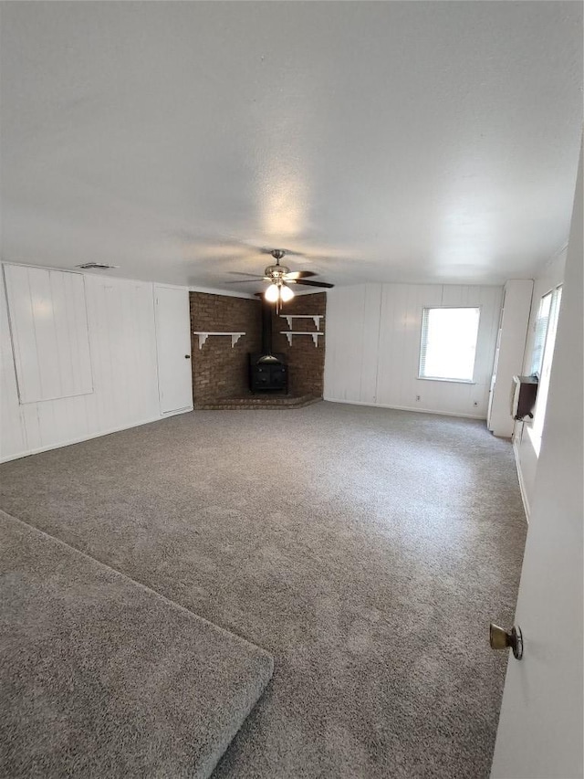 405 Oertli Ln, Austin, TX 78753 - unfurnished living room with a wood stove, carpet flooring, and ceiling fan