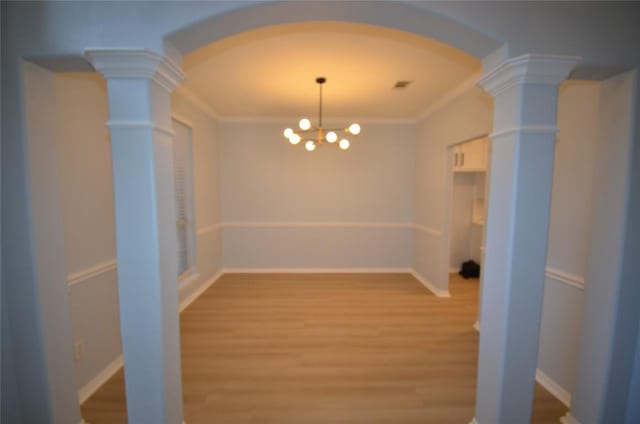 840 Smoke Signal Pass, Pflugerville, TX 78660 - unfurnished dining area featuring ornate columns, arched walkways, light wood-type flooring, a chandelier, and crown molding