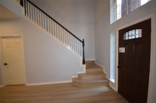 840 Smoke Signal Pass, Pflugerville, TX 78660 - foyer featuring stairs, wood finished floors, a high ceiling, and baseboards
