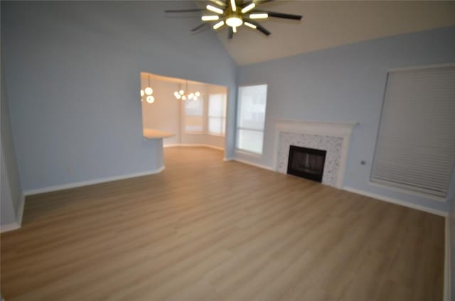 840 Smoke Signal Pass, Pflugerville, TX 78660 - unfurnished living room featuring a ceiling fan, wood finished floors, baseboards, a chandelier, and a fireplace