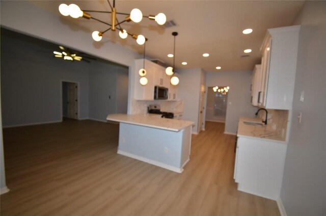 840 Smoke Signal Pass, Pflugerville, TX 78660 - kitchen with stainless steel microwave, a chandelier, stove, white cabinets, and recessed lighting