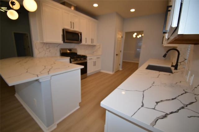 840 Smoke Signal Pass, Pflugerville, TX 78660 - kitchen with stainless steel appliances, a sink, a peninsula, light wood-style flooring, and tasteful backsplash