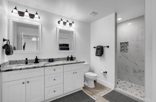 249 Hill Dr, Granite Shoals, TX 78654 - full bath featuring double vanity, a marble finish shower, toilet, baseboards, and recessed lighting