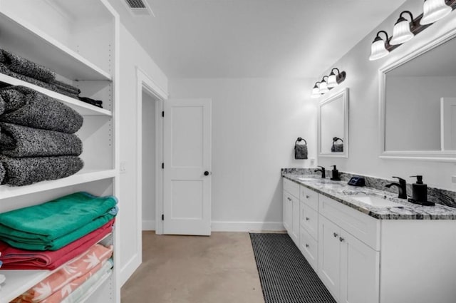 249 Hill Dr, Granite Shoals, TX 78654 - bathroom with double vanity, finished concrete flooring, and baseboards