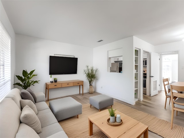 7920 Rockwood Ln Unit 208, Austin, TX 78757 - living room featuring light wood-style flooring, healthy amount of natural light, and baseboards