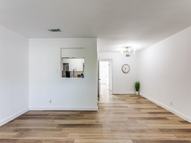 7920 Rockwood Ln Unit 208, Austin, TX 78757 - empty room with light wood-style floors, a chandelier, and baseboards