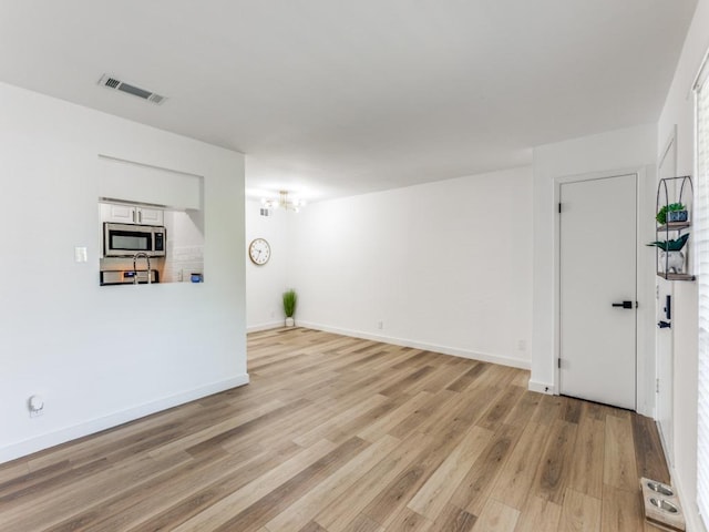 7920 Rockwood Ln Unit 208, Austin, TX 78757 - unfurnished living room featuring light wood finished floors and baseboards