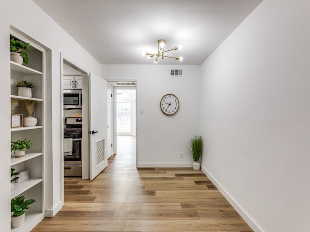7920 Rockwood Ln Unit 208, Austin, TX 78757 - corridor with light wood-style flooring, a chandelier, baseboards, and built in features