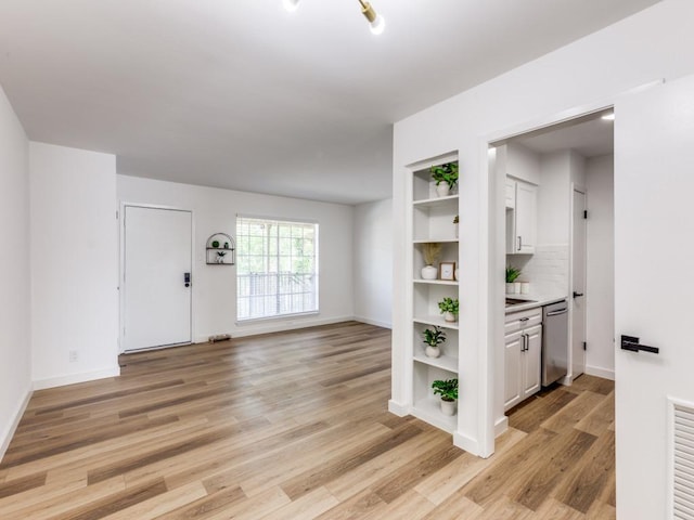 7920 Rockwood Ln Unit 208, Austin, TX 78757 - unfurnished living room featuring light wood-type flooring and baseboards