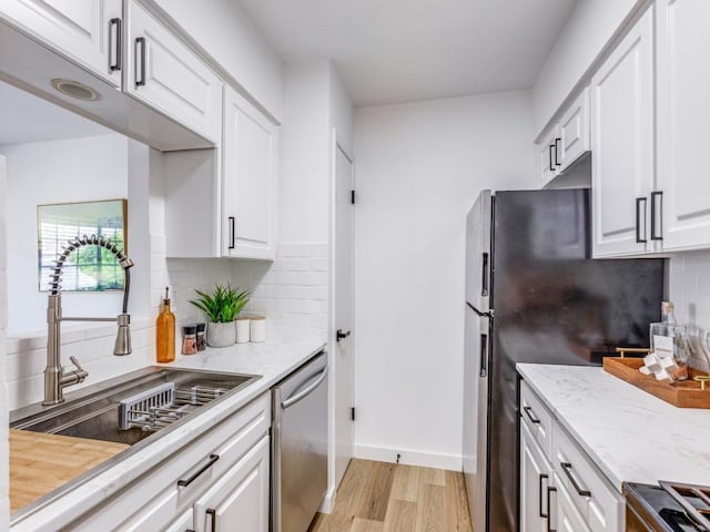 7920 Rockwood Ln Unit 208, Austin, TX 78757 - kitchen featuring appliances with stainless steel finishes, a sink, light wood-style flooring, and white cabinets