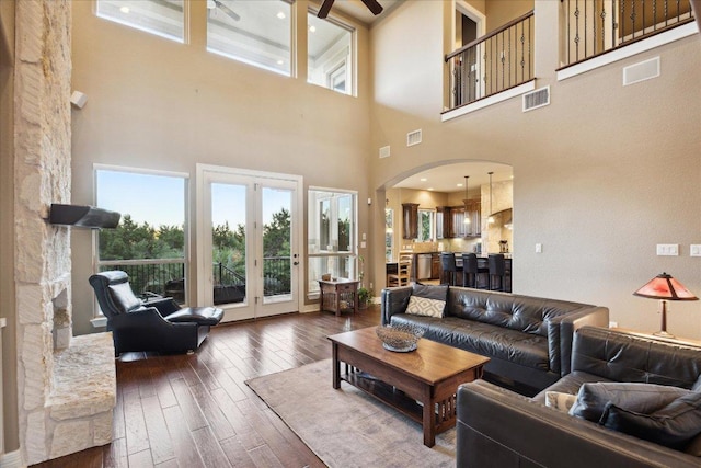 613 Horseback Holw, Austin, TX 78732 - living area featuring arched walkways, dark wood-type flooring, a ceiling fan, and a high ceiling