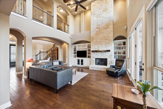 613 Horseback Holw, Austin, TX 78732 - living area featuring a ceiling fan, a towering ceiling, stairway, built in features, and hardwood / wood-style flooring