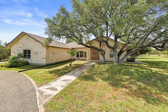 217 Circle Oaks Dr, Burnet, TX 78611 - view of front facade featuring stone siding and a front yard