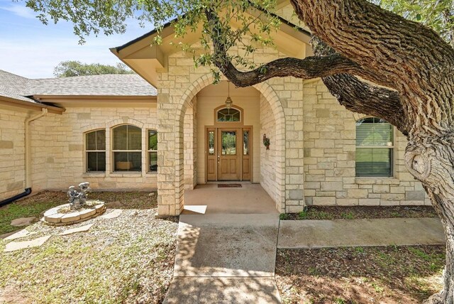 217 Circle Oaks Dr, Burnet, TX 78611 - entrance to property featuring stone siding and a shingled roof