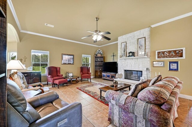 217 Circle Oaks Dr, Burnet, TX 78611 - living area with tile patterned floors, crown molding, ceiling fan, a stone fireplace, and baseboards