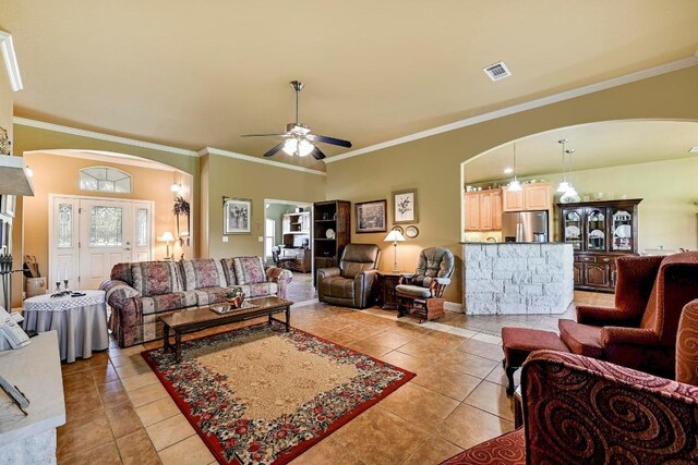 217 Circle Oaks Dr, Burnet, TX 78611 - living area with arched walkways, light tile patterned floors, crown molding, ceiling fan, and baseboards