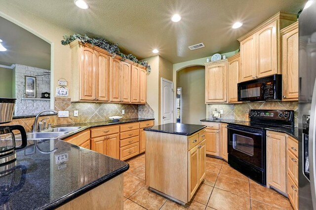 217 Circle Oaks Dr, Burnet, TX 78611 - kitchen with black appliances, a sink, light brown cabinetry, a center island, and tasteful backsplash