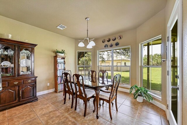 217 Circle Oaks Dr, Burnet, TX 78611 - dining area with a chandelier, light tile patterned floors, and baseboards