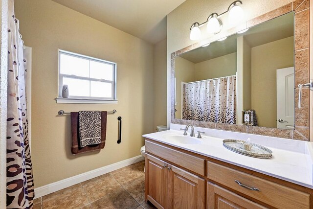 217 Circle Oaks Dr, Burnet, TX 78611 - bathroom with vanity, toilet, baseboards, tile patterned flooring, and a shower with curtain