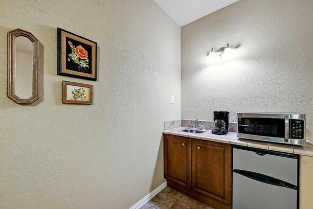 217 Circle Oaks Dr, Burnet, TX 78611 - bathroom with a sink, baseboards, a textured wall, and tile patterned floors