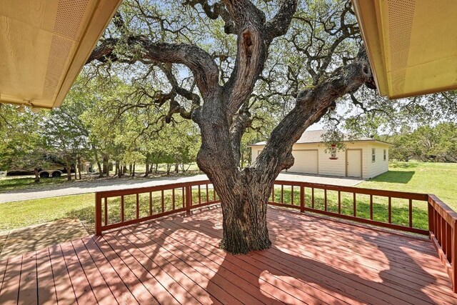 217 Circle Oaks Dr, Burnet, TX 78611 - wooden terrace with a lawn, a garage, an outdoor structure, and view of scattered trees